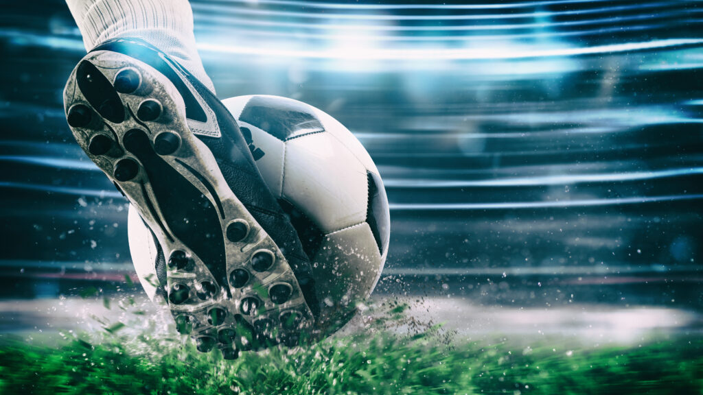 Soccer player kicks the ball vigorously at the stadium